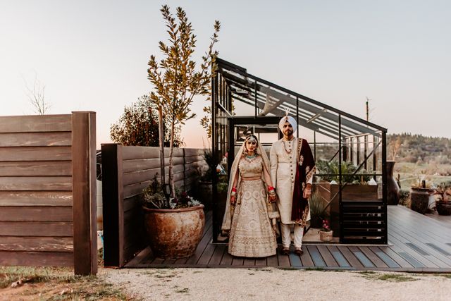 Bride and groom by the green house at Black Oak Mountain Vinery